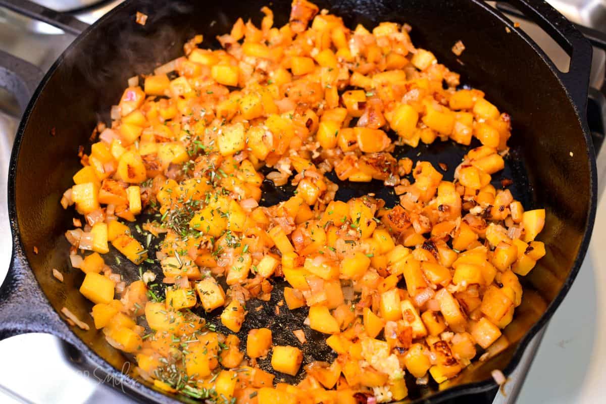 Diced peaches and onions caramelizing in a cast-iron skillet, creating a sweet topping for pork chops