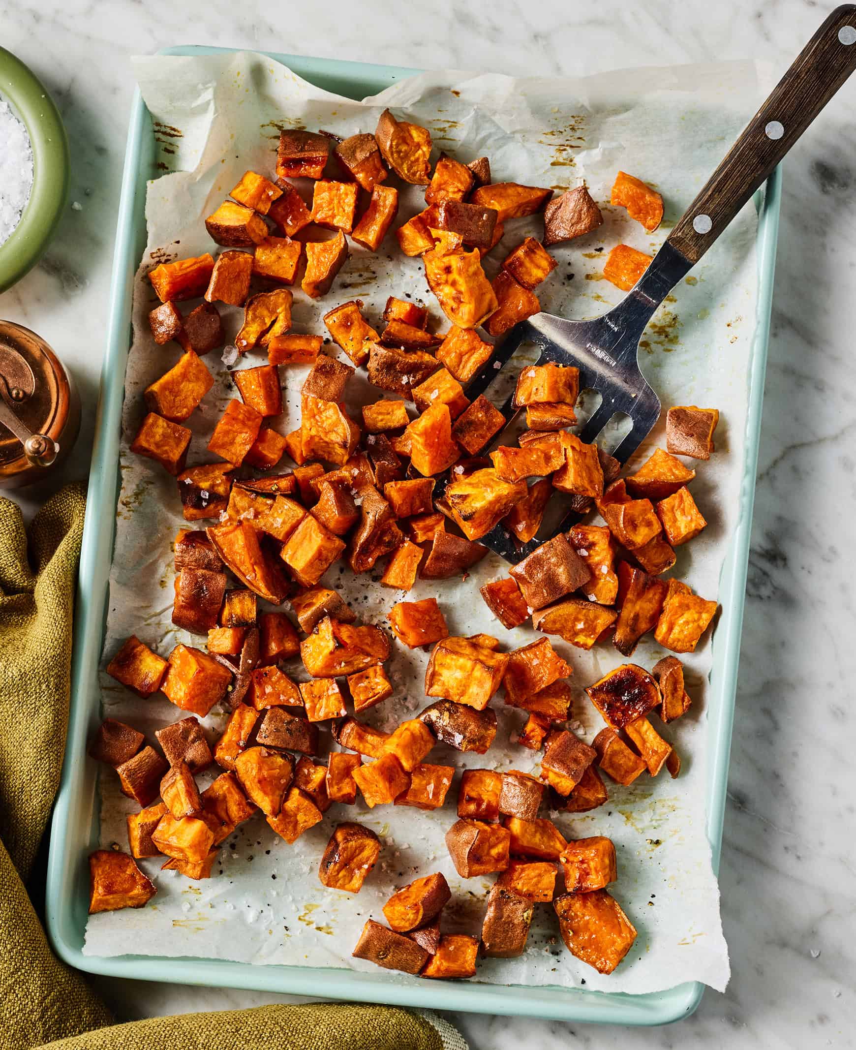 Oven roasted sweet potatoes on baking sheet lined with parchment paper
